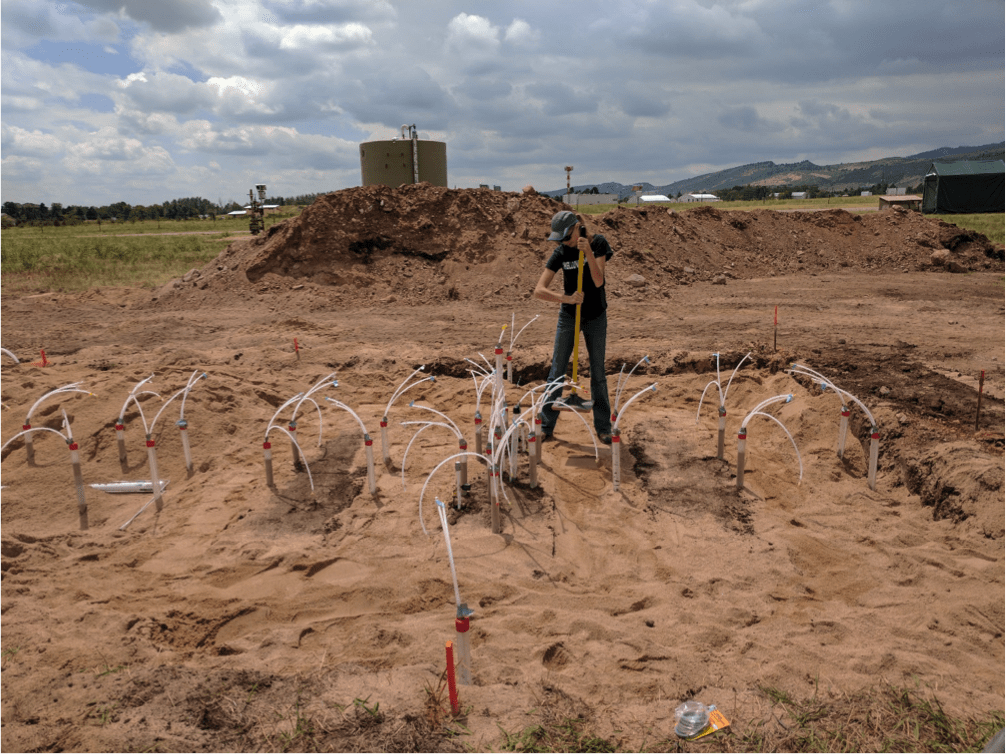 girl digging hole in ground for pipeline